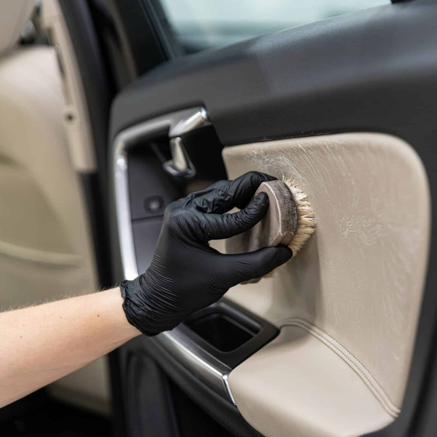 Persona tīra automašīnas durvis no iekšpuses